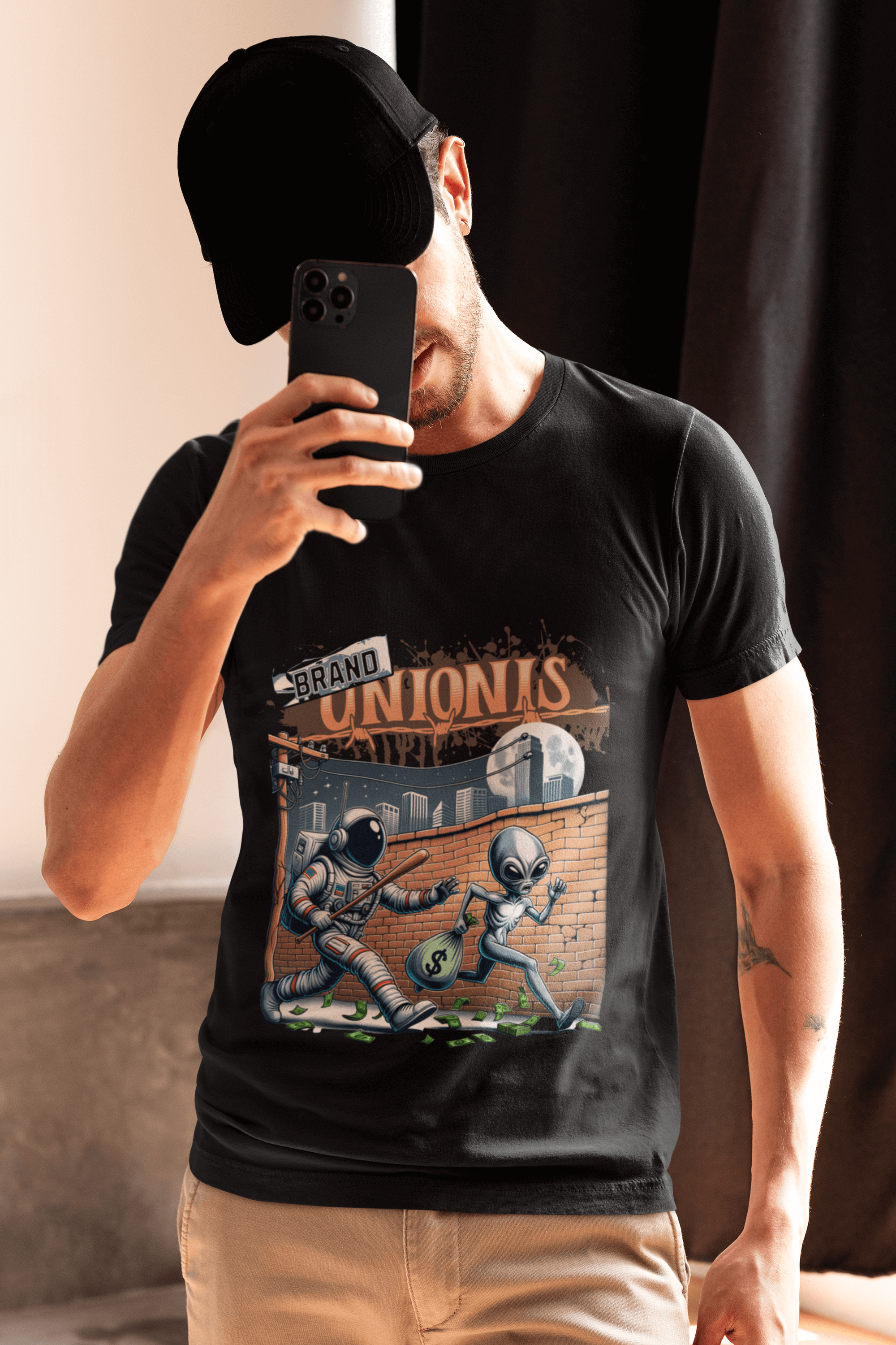 Uomo che indossa una t-shirt nera unisex dalla vestibilità regolare con grafica aliena spaziale, realizzata in 100% cotone, 180 gr.